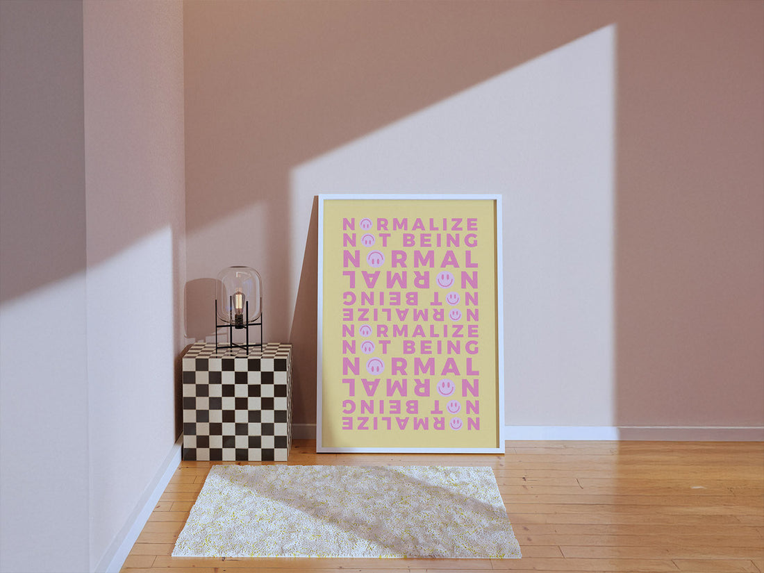 A soft sunlighted room with framed poster for non-normative affirmation. A coral vase sits on a checkered cube next to it for a minimalist room decor