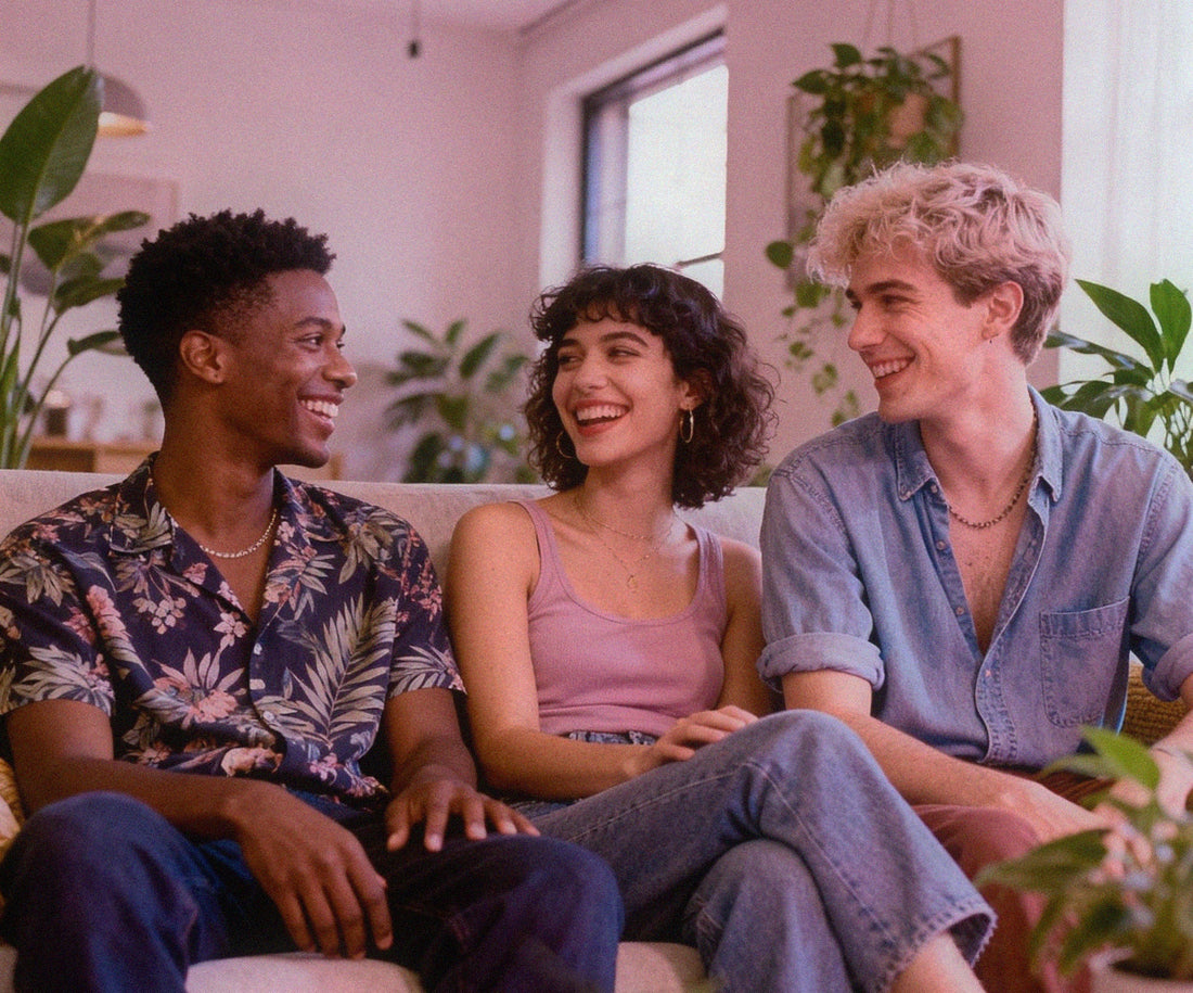 Queer throuple relaxing together on a couch in a warm modern living room, with plants and a couch.
