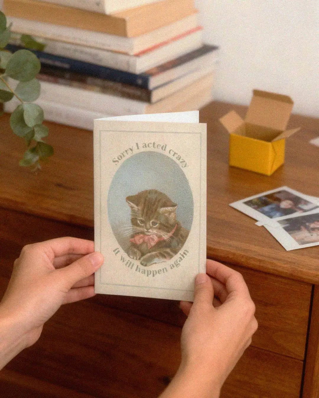 Hands holding an apology card with a vintage kitten image and text, "Sorry I acted crazy, it will happen again." Funny card for neurospicy people.