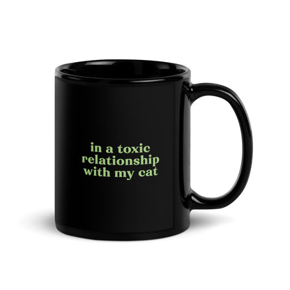 Glossy black ceramic mug with toxic cat relationship quote in green – sarcastic cat lover drinkware for introverts and emotional chaos