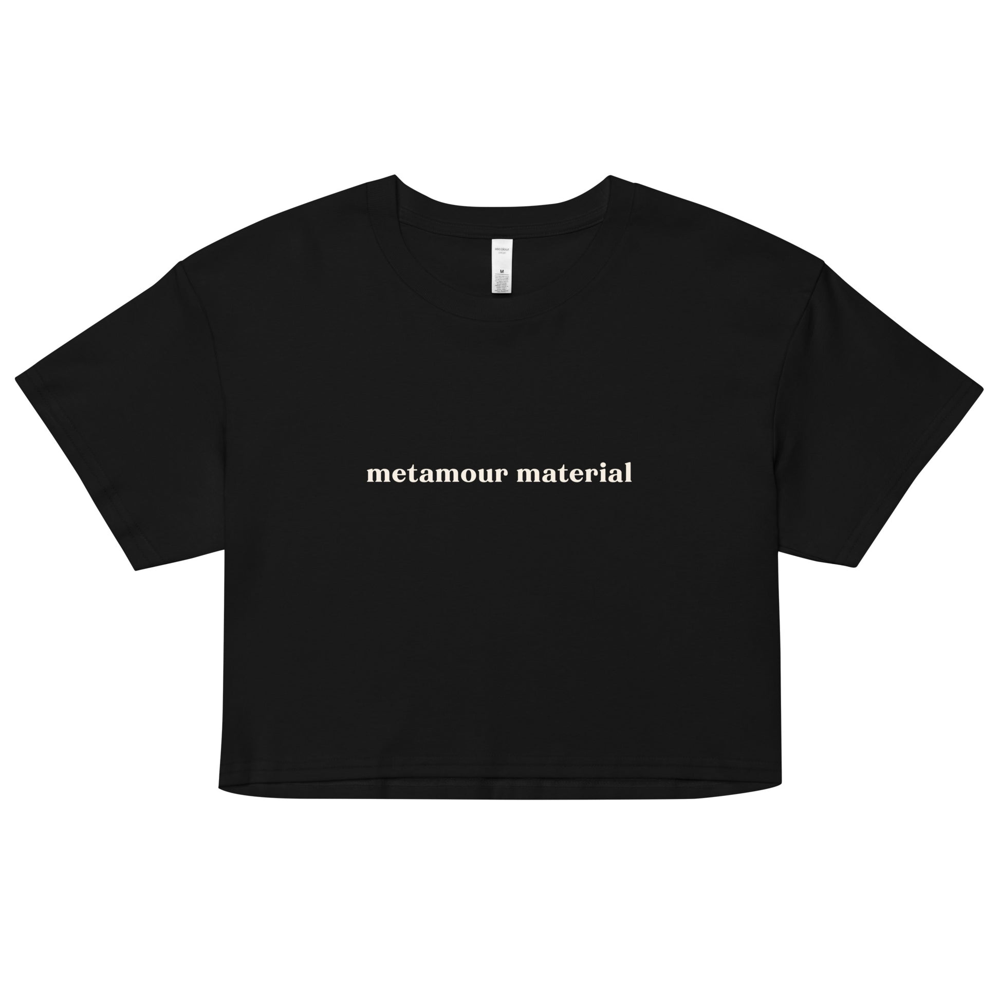 Black crop top with cream text saying “Metamour Material” for ethical non-monogamy and ENM statement wear.