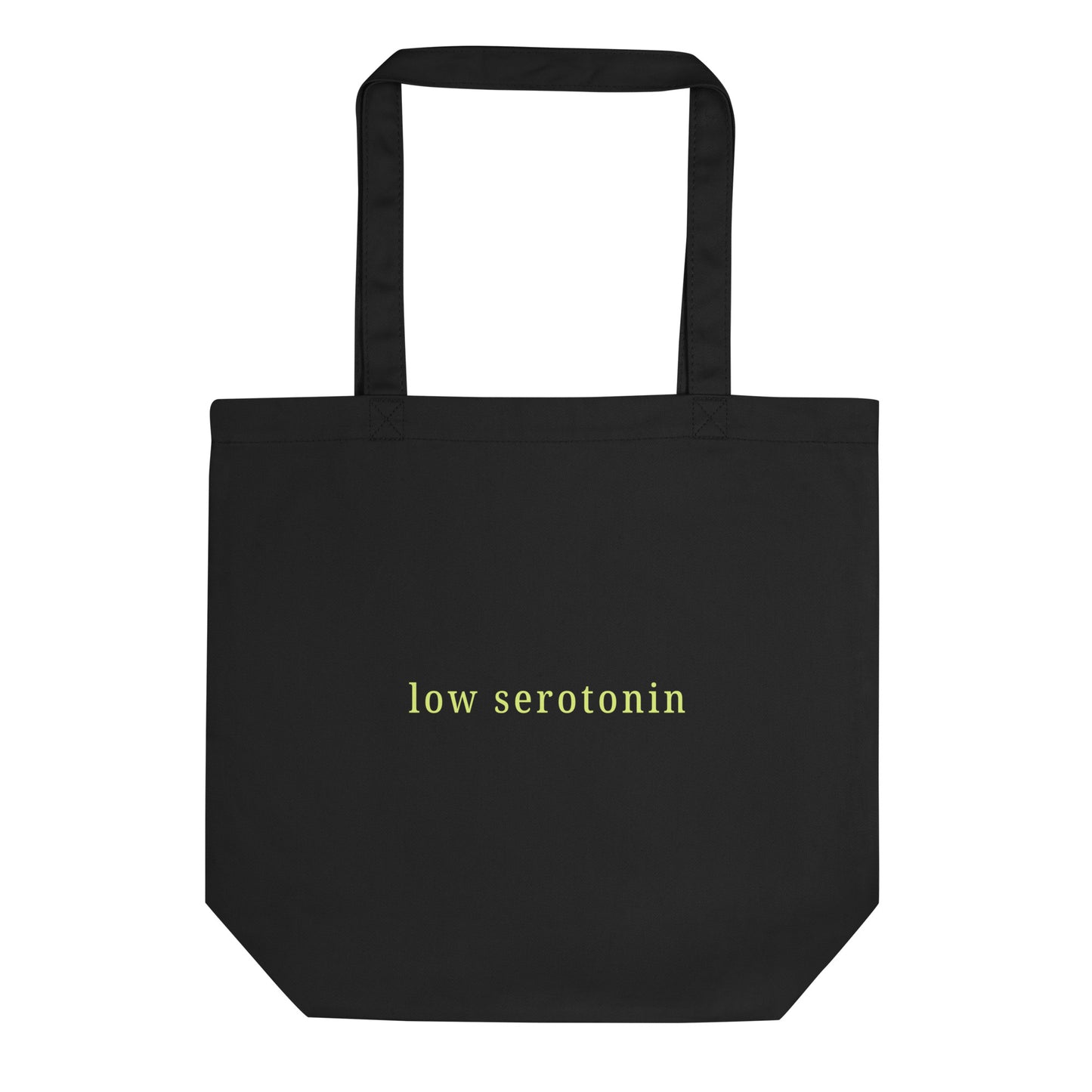 Black eco cotton tote bag with bold yellow-green text “low serotonin” – sarcastic neurodivergent statement carryall for everyday style.