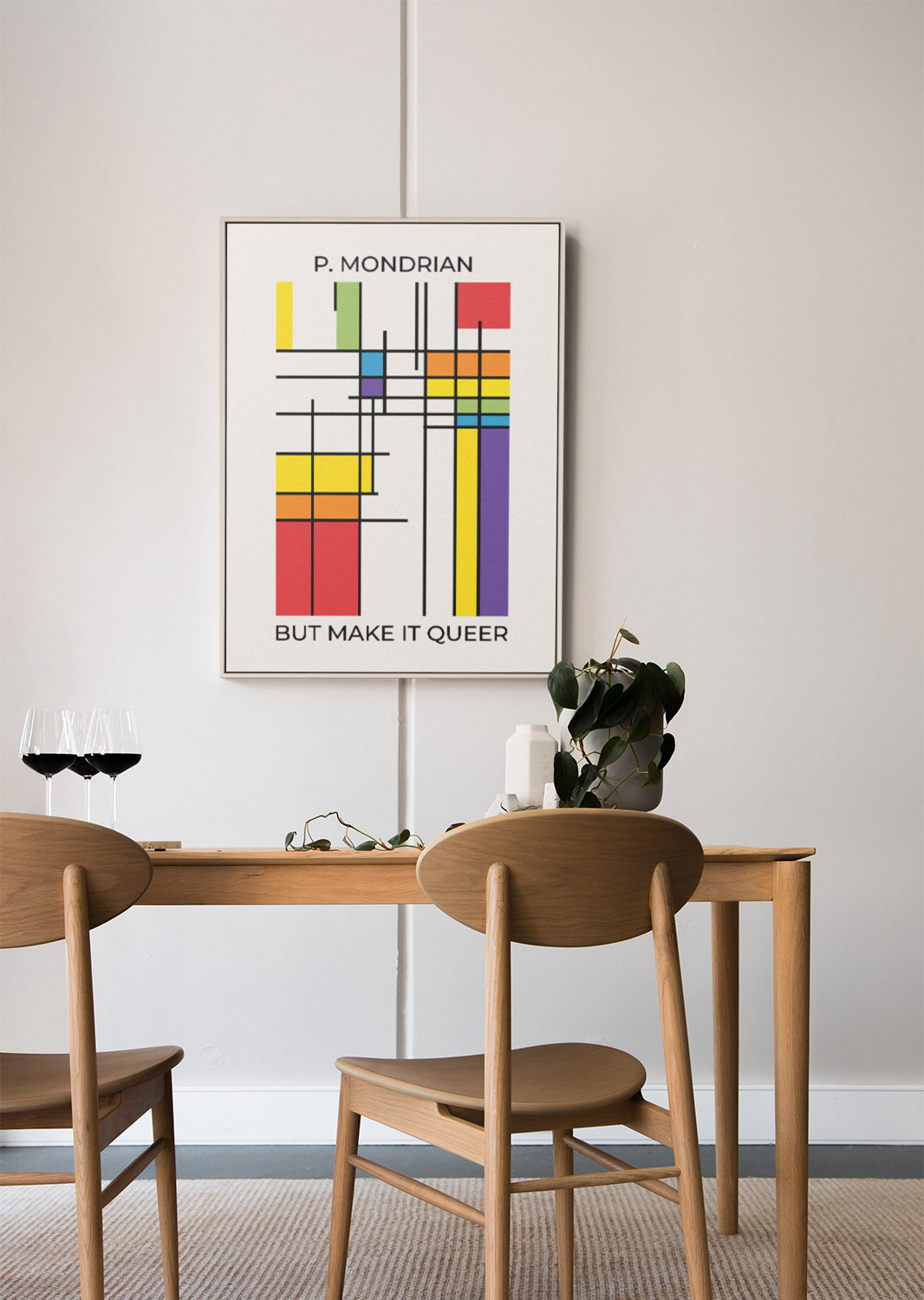Framed Mondrian inspired queer pride poster hangs above a wooden dining table set with two wine glasses, a plant, and minimalistic decor, conveying a cozy, cool vibe.