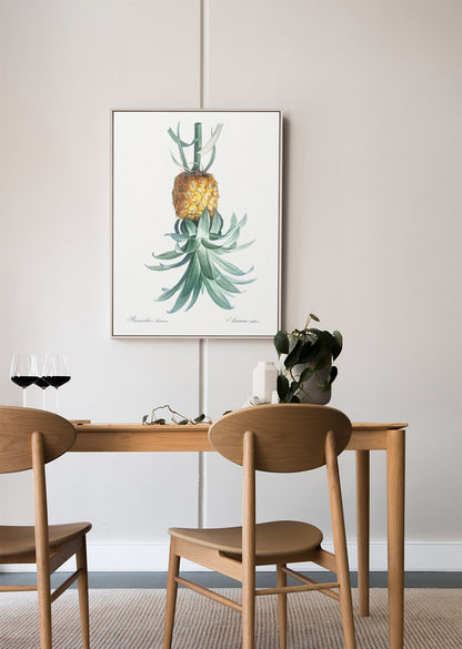 A reverse pineapple illustration for pleasure-positive home decor hangs above a wooden dining table for everyday affirmation at home