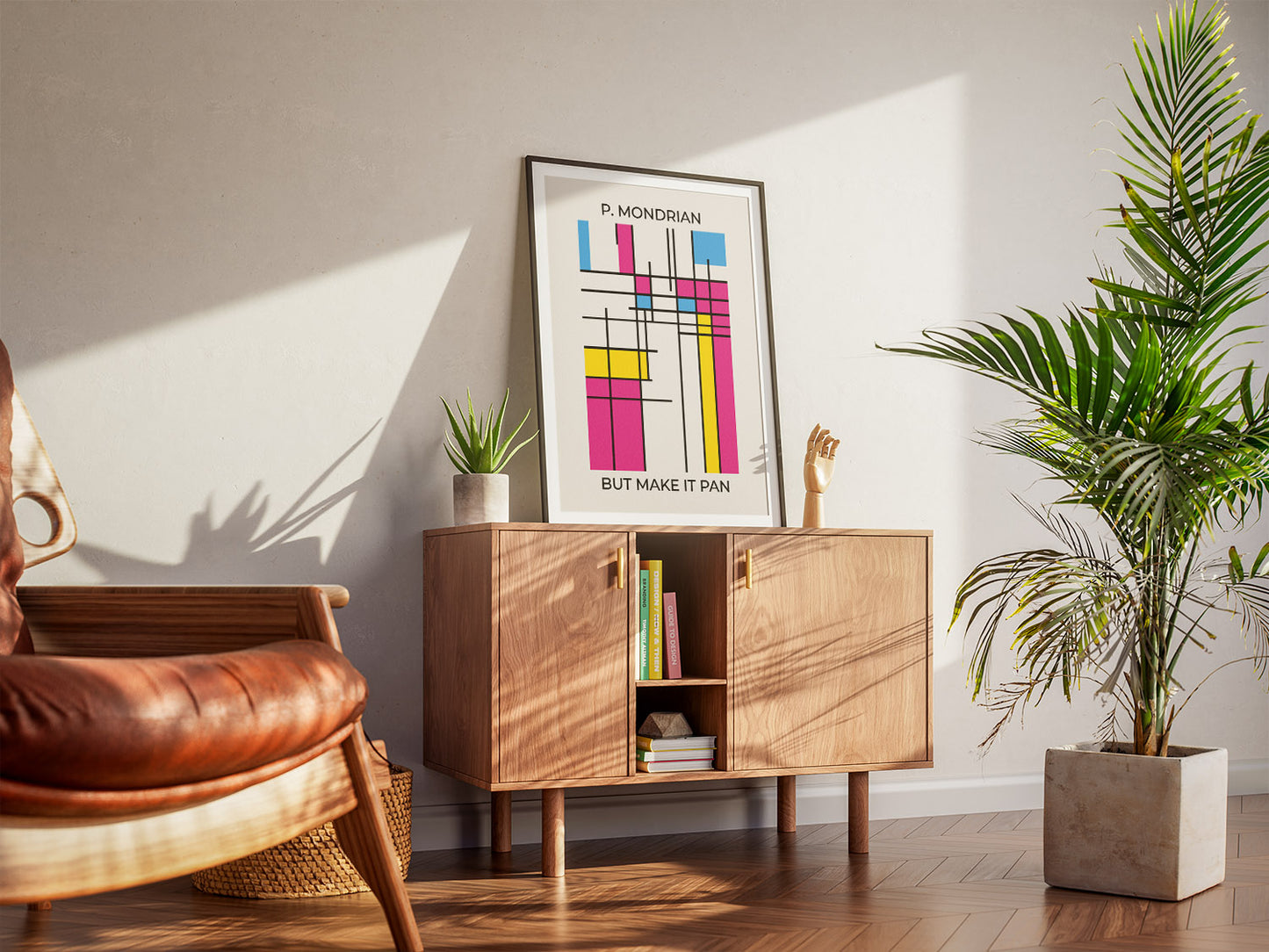 A cool living room with a framed pansexual pride abstract wall art inspired by Mondrian. A wooden armchair, a cabinet and houseplants create a warm, inviting atmosphere.