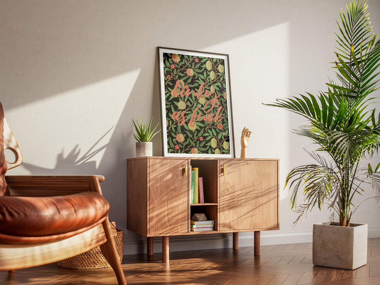 A cool living room with a framed vintage-inspired body-positive colorful wall art. A wooden armchair, a cabinet and houseplants create a warm, inviting atmosphere.