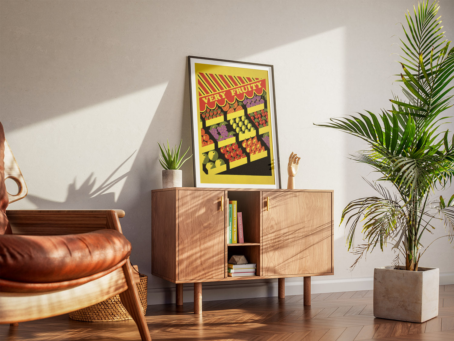 A cool living room with a framed Very Fruity printable poster for colorful queer home decor. A wooden armchair, a cabinet and houseplants create a warm, inviting atmosphere.