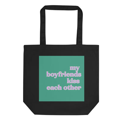 Black eco cotton tote bag featuring a mint green square design with pastel retro text reading “My Boyfriends Kiss Each Other,” celebrating queer polyamory and ENM humor.