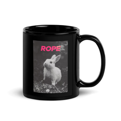 Glossy black ceramic mug with bold pink ROPE text above a black-and-white bunny print – playful rope art gift or desk bold accessory
