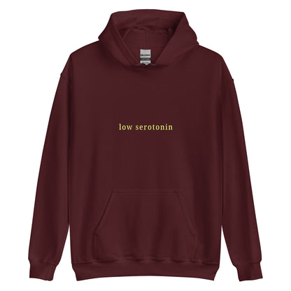 Unisex hoodie with minimalist yellow-green text reading “Low Serotonin” – sarcastic neurodivergent sweatshirt for cozy everyday style.