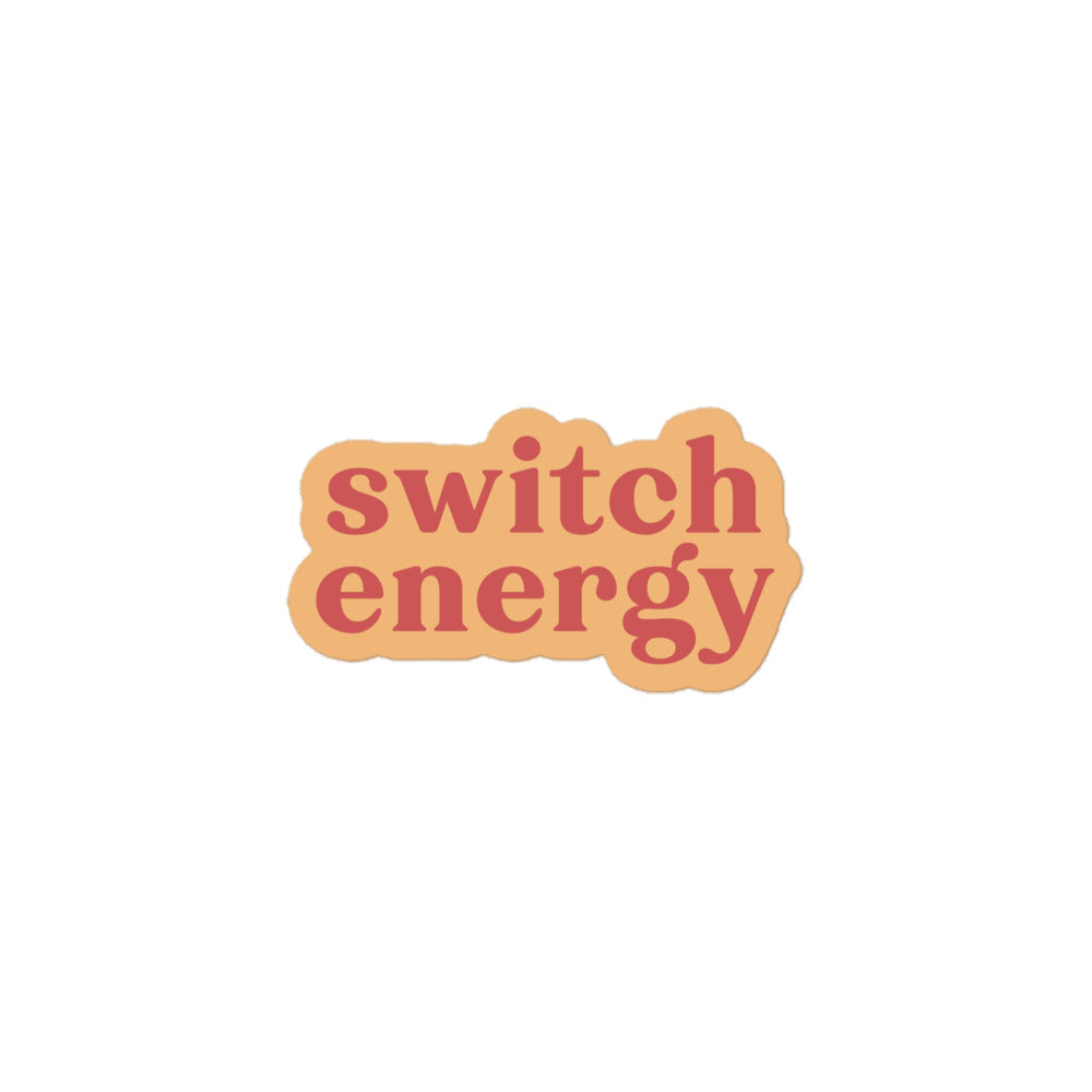 Vinyl sticker with light peach background and soft red text reading “switch energy,” versatile play-positive decal for laptops, bottles and journals.