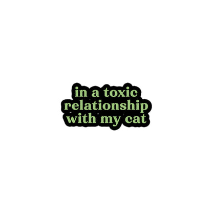 Vinyl sticker with green text saying “in a toxic relationship with my cat” for cat lovers with sarcastic dating dread.