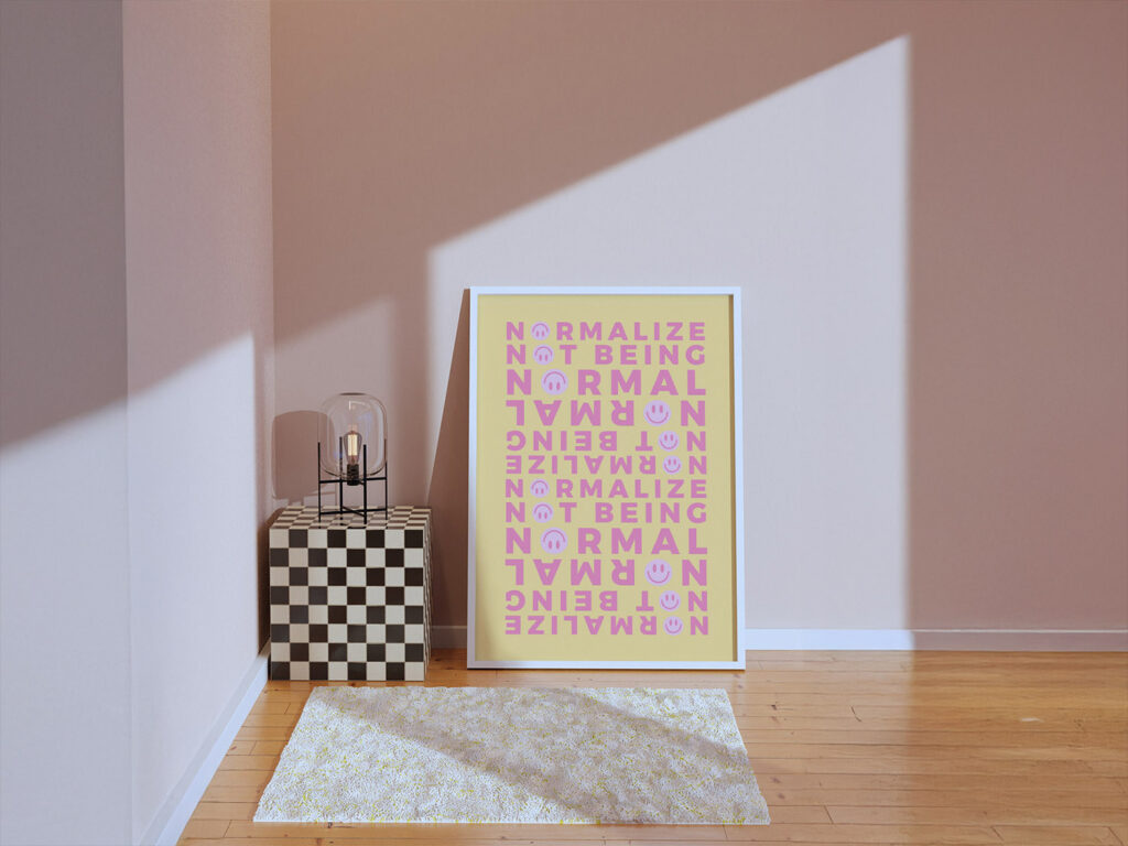 A modern minimalist room with a light colored wall, surrounded by bold decor elements like a checkered stand, a modern table lamp, and a framed wall art print with the repeated phrase ‘NORMALIZE NOT BEING NORMAL’ in cheerful colors.